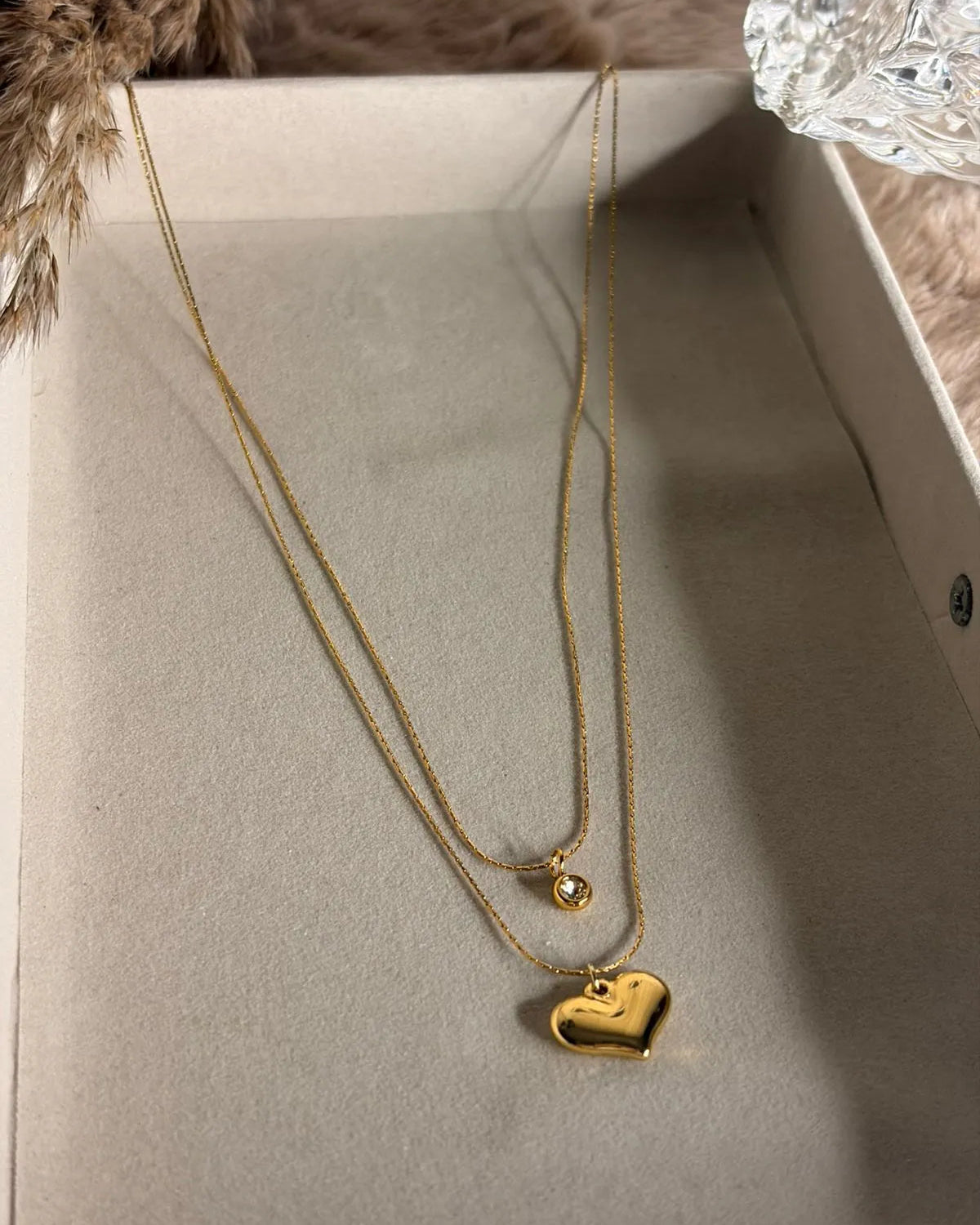 Double Layered Necklace With a Heart Pendant and a Stone